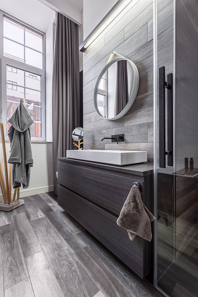 Wooden bathroom with round mirror